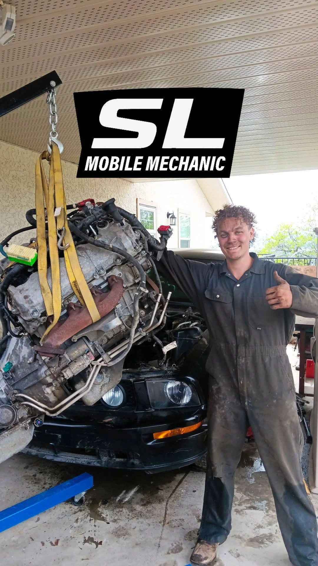 Sam alongside an engine he has lifted out of a vehicle